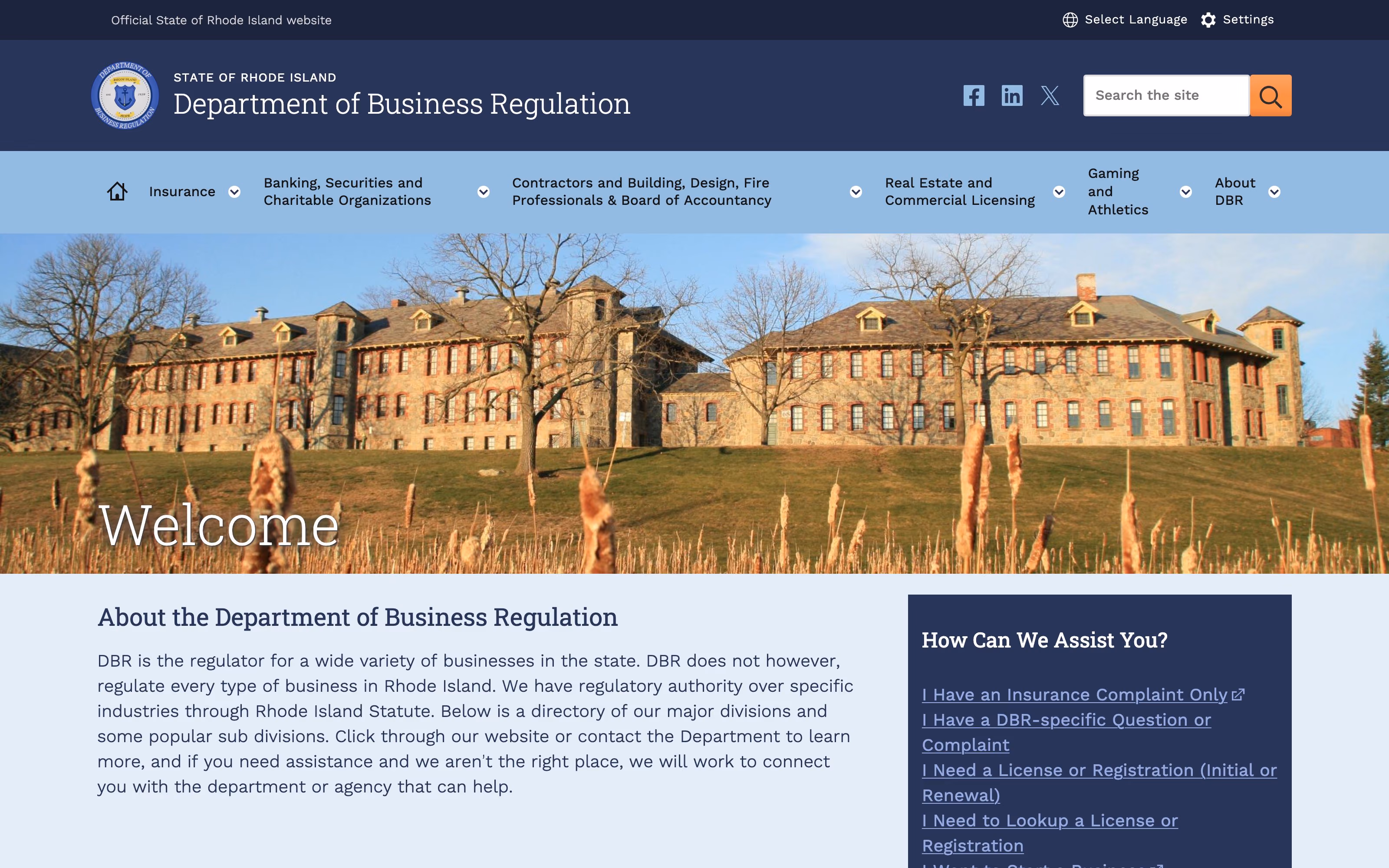 The Rhode Island Department of Business Regulation website. A utility bar across the top offers Select Language and Settings; beneath it a navy header shows the department’s seal, “STATE OF RHODE ISLAND” above the department name, social links and a search field; a blue navigation band lists Insurance, Banking, Contractors, Real Estate, Gaming and About; below that a photograph of a stone state building under the heading “Welcome”.
